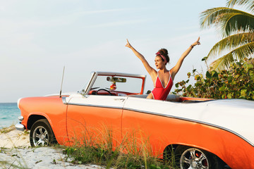 Sexy woman in red swimsuit and retro cabriolet car - obrazy, fototapety, plakaty