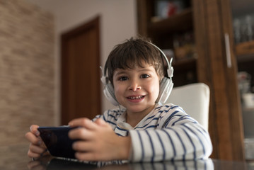 boy at home looking at the phone with headphones