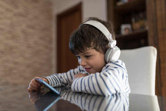 boy at home looking at the phone with headphones