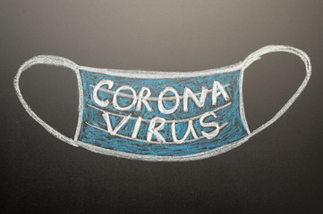 A drawn mask on a blackboard with the inscription Coronavirus. News headline, articles. Epidemic...
