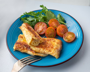 Breakfast of rolled omelette and Beijing cabbage, cherry tomato halves for a light breakfast