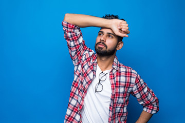 Portrait of a handsome indian man sad isolated on blue background