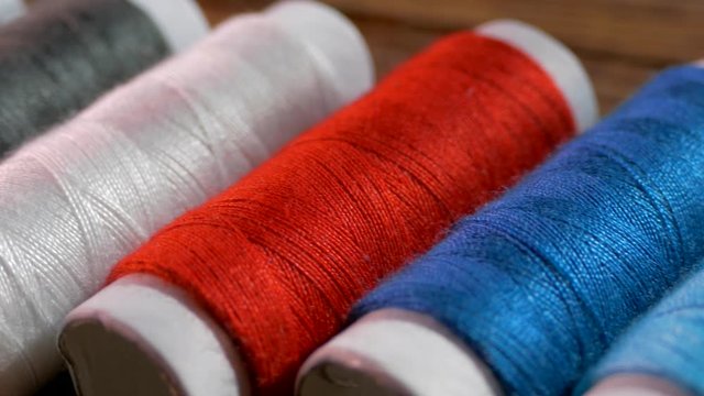 Spools of colored thread close-up. Textile industry. Sew with a needle and thread. Embroider on fabric.