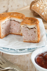 Traditional style British pork pie made with chopped pork jellied pork stock and a hot water crust pastry