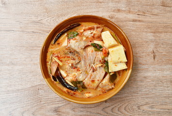 spicy boiled Tilapia fish with slice coconut shoot in tom yum milk soup on bowl