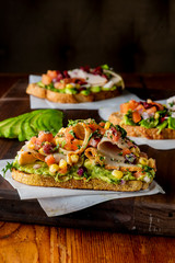 Avocado Toast. Fresh organic avocados mixed with olive oil lemon and salt and pepper paired with radishes micro greens and celery leaves. Spread on whole grain crispy toast. New American favorite.