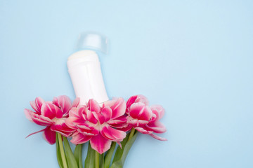 natural mineral deodorant for women, with a blooming flowers on blue background with a copy space
