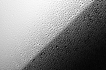 Abstract diagonal black and white texture of water drops on the glass