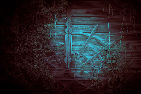 The House Is Horror, Scary, Darkness. Ghostly Gloomy Facade Of An Abandoned Ghostly Wooden Building In The Night Mystical Red And Blue Light With Eerie Strange Shadows Of A Weaving Plant