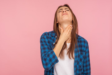 Throat pain. Portrait of flu sick girl in checkered shirt touching her inflamed throat and...