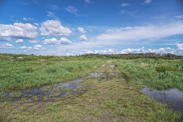 Spring flood in the field. Colorful swamp in the shake. Land reclamation on the territory and in the world. Landscape of a road in the water