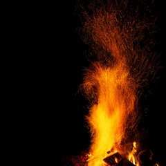 Campfire with sparks on a black background with a copy space