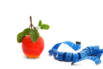 Measuring tape and an apple on a white background
