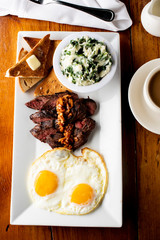Steak and Eggs. Traditional classical American or French Bistro brunch item favorite: steak and eggs. Steak, served medium raw with sunny side up eggs.  