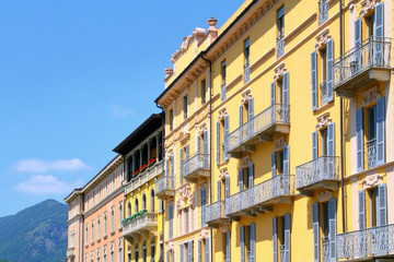 Fototapeta na wymiar WINDOWS AND BALCONIES OF HISTORICAL COLORED BUILDINGS IN COMO CITY IN ITALY 