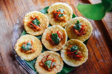 Crispy rice cake and pork and shrimp dipping in plate on wood table. thai food