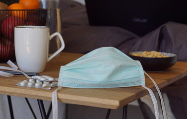 stying home during coronavirus pandemia, surgical mask lying on a table