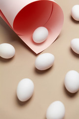 Creative Easter beige and pink background with white eggs. Easter holiday minimal concept.