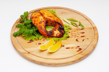 salmon steak with lemon on a wooden dish