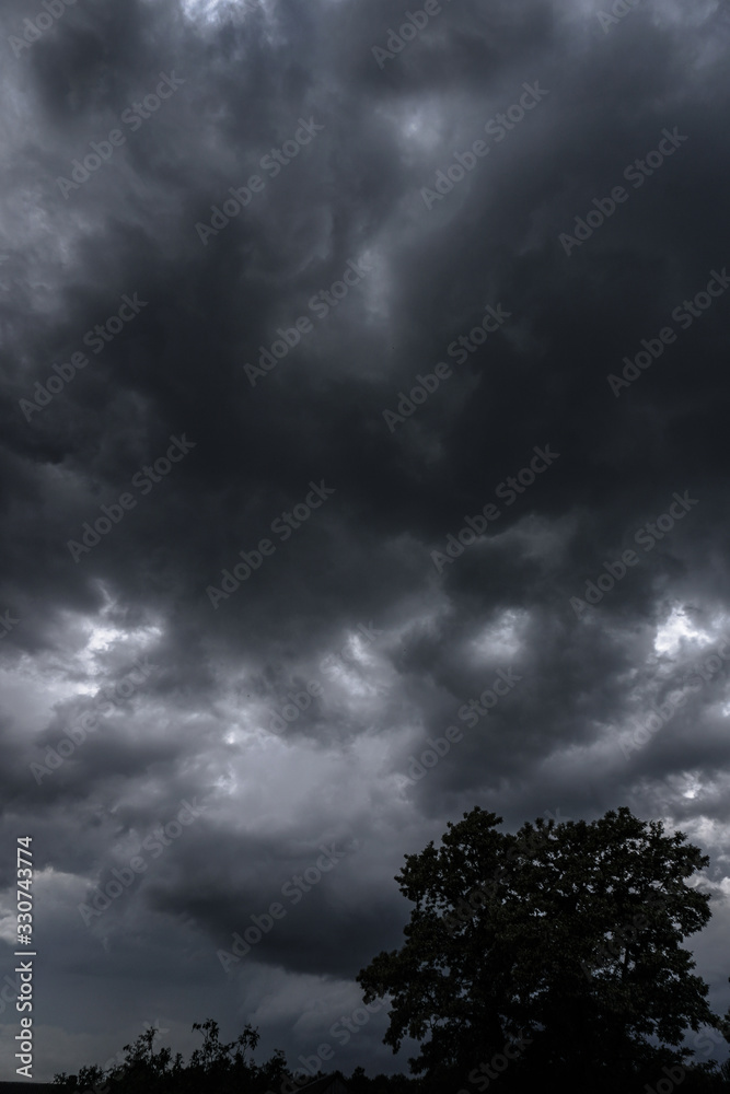 Wall mural terrible thunderclouds from the side of a plane. gloomy epic clouds. background image in a dark gray