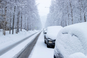 Siberia. Morning on a city street. Cars and road in the snow after a snowfall.