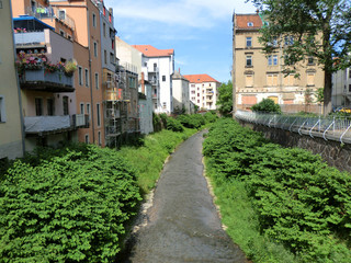 a small river flowing between houses in the city