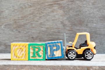 Toy forklift hold letter block P to complete word CRP (abbreviation of C-Reactive Protein Test) on wood background