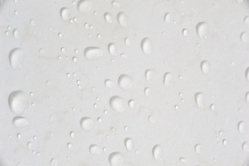 Beautiful water drops at a clean wall in difference sizes from small ones to big ones nice and...