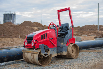 Road roller working at construction site during asphalt road repair. Paving roller machine on paving works.