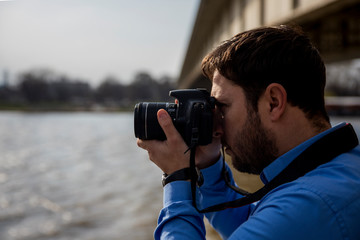 Photographer photographing outdoors. Shooting in urban city environment