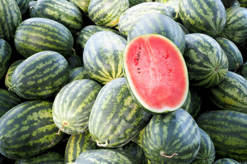 Half watermelon one pice on lot of water melons, Healthy eating. Lots of juicy and ripe watermelons.