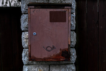 Street mailbox hanging on a stone wall