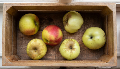 Garden green apples inside a wooden textured fruit box.