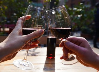 Glasses with the red vine, and the meal outdoors with beautiful weather.