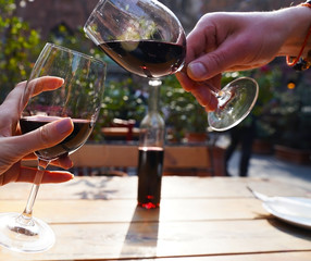 Glasses with the red vine, and the meal outdoors with beautiful weather.