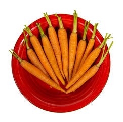 Small carrots in a red plate isolated on a white background. Top view.. Flat lay