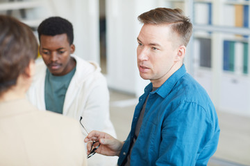 Obraz premium Portrait of adult man sharing life story while sitting on chair in support group circle or psychology center
