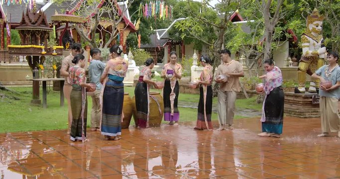 The summer holiday water festival in april the people celebrate traditional asian thai songkran the beautiful women and men smiling splash water with hapiness.