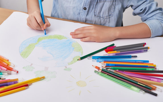 Child Boy  Draws  Planet For Earth Day. Protection Of Enviroment, Mother Earth Day Greeting And Celebration. Save Our Planet! Concept Of Art Learning And Education, Love Earth , Save World And Unity