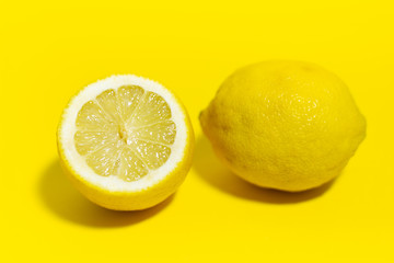 Studio picture, close-up of lemon on yellow background.