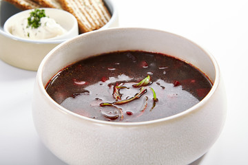 Borscht in bowl with roasted toasts and sour cream