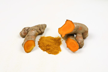 Turmeric powder and fresh turmeric roots isolated on a white background is an ingredient in turmeric foods and ingredients in skin care products. Turmeric helps the skin to be strong