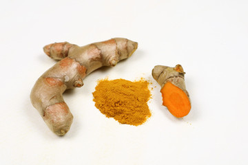 Turmeric powder and fresh turmeric roots isolated on a white background is an ingredient in turmeric foods and ingredients in skin care products. Turmeric helps the skin to be strong