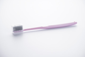 Pink toothbrush in a case on a white background.