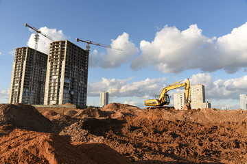 Excavator during Earthmoving Works at construction site. Backhoe digs the foundations of the...