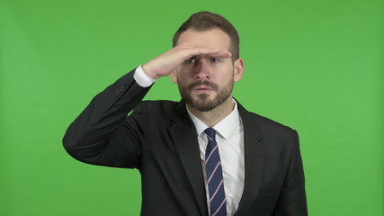 The Ambitious Businessman trying to Look far off against Chroma Key