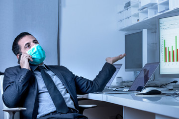 Manager in abito si protegge con una mascherina e discute al celliulare seduto nella poltrona della...