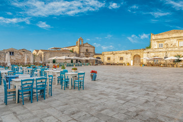 Beautiful and colorful main square and view of the famous cafe of small coastal town Marzamemi in Sicily, south Italy
