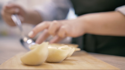Girl straightens hands italian ravioli close-up