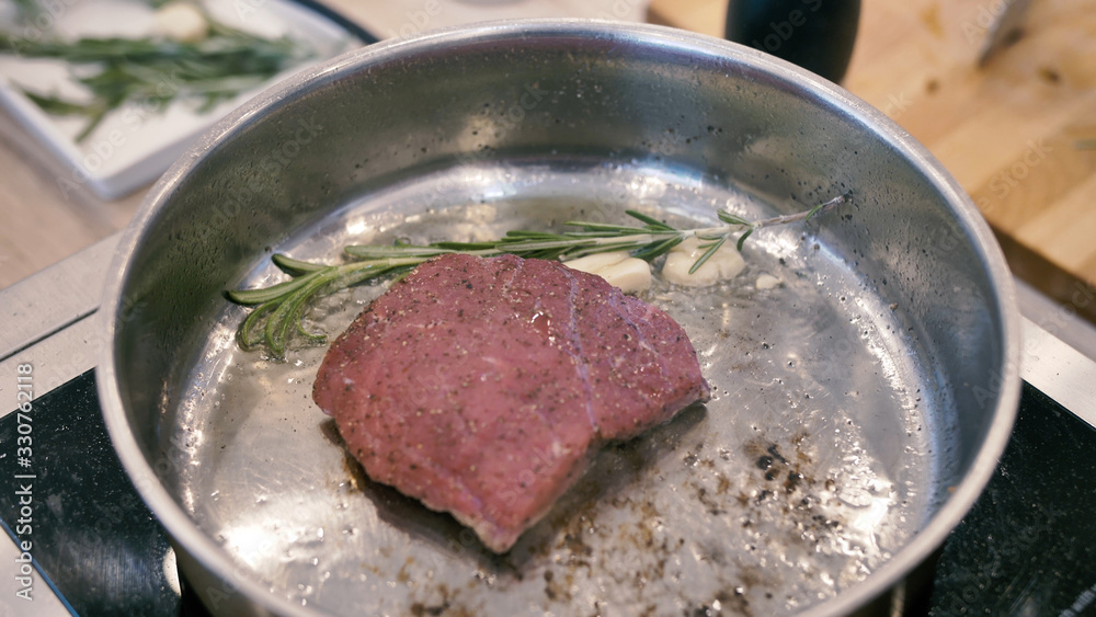 Wall mural delicious meat steak fried in a pan with rosemary